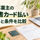個人事業主の請求書カード払いについて手数料と条件を比較する記事の見出しと仕事机